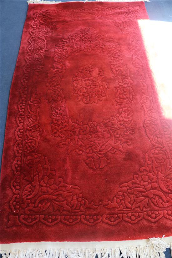 A Chinese red ground carpet, 220 x 120cm
